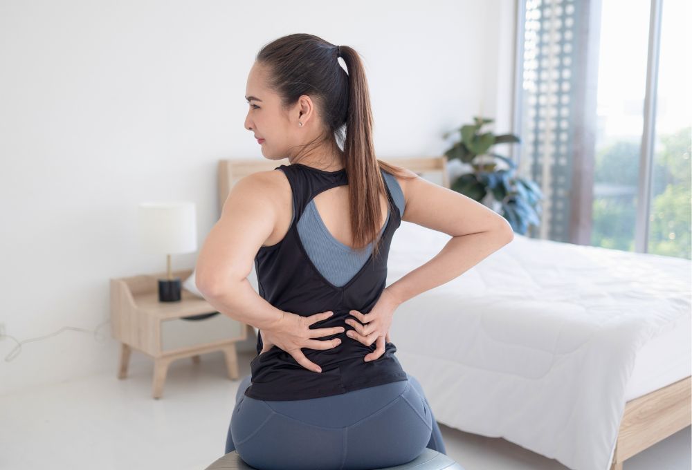 woman with back pain from a mattress that is sagging and too soft