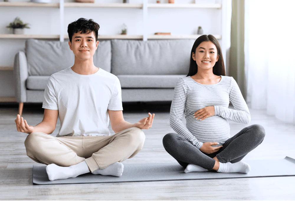 A pregnant women and her husband practicing meditation. This blog breaks down how pregnancy may affect the sleep quality in pregnant women.